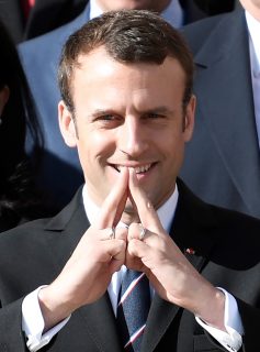 New French President Emmanuel Macron gestures to make the form of the Eiffel tower with his hands as he poses at the Elysee Palace in Paris after a meeting with members of the International Olympic Committee (IOC) Evaluation Commission, on May 16, 2017, prior to a vote for the 2024 Summer Olympics. / AFP PHOTO / STEPHANE DE SAKUTIN