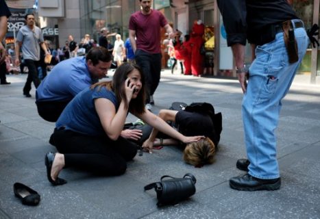 EDITORS NOTE: Graphic content / People attend to an injured man after a car plunged into him in Times Square in New York on May 18, 2017.  A car plowed into a crowd of pedestrians in New York's bustling Times Square, leaving one person dead and at least 12 other injured in what officials said was an accident.  / AFP PHOTO / Jewel SAMAD