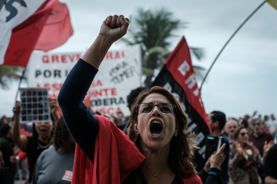 A protester shouts slogans in front of the house of lower house speaker Rodrigo Maia -who would initially take over the presidency if President Michel Temer resigns or is impeached- during a protest against Temer in Rio de Janeiro, Brazil, on May 21, 2017. Maia is one of the many legislators being investigated in the "Car Wash" probe, the biggest corruption investigation in Brazil's history. Temer won a reprieve Sunday when a key coalition partner delayed a decision on whether to abandon him over an explosive corruption scandal. / AFP PHOTO / Yasuyoshi Chiba