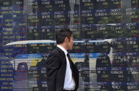 A man looks at a stock quotation board of the Tokyo Stock Exchange in front of a securities company in Tokyo on May 22, 2017.  Tokyo stocks opened higher on May 22, tracking gains on Wall Street last week as higher oil prices lifted energy shares. / AFP PHOTO / Kazuhiro NOGI