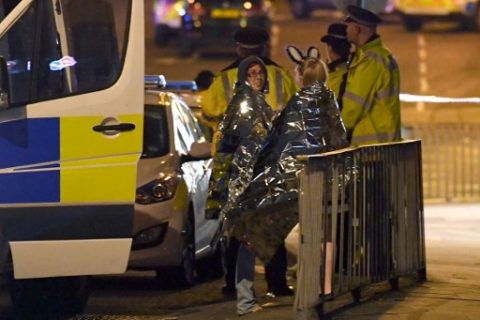 Concert goers wait to be picked up at the scene of a suspected terrorist attack during a pop concert by US star Ariana Grande in Manchester, northwest England on May 23, 2017. The man behind a terror attack at a pop concert in Manchester late Monday died when he detonated his device, killing 22 others including children and injuring 59 people, police said on May 23. / AFP PHOTO / Paul ELLIS / ALTERNATIVE CROP