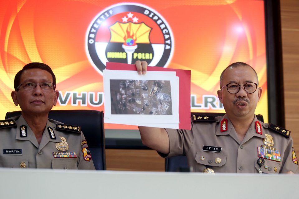 Indonesian police spokesmen Setyo Wasisto (R) and Martinus (L) show a photograph of gathered material collected as evidence from a suicide bombing site, during a press conference in Jakarta on May 25, 2017. Indonesia's elite anti-terror squad was on May 25 investigating a suicide bombing attack near a busy Jakarta bus station that killed three policemen, the latest assault in the Muslim-majority country as it faces a surge in militant plots. / AFP PHOTO / ADIBA