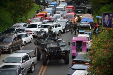An armored personnel carrier moves amongst stuck vehicles of residents fleeing Marawi, in the southern island of Mindanao on May 25, 2017, as fighting rages between government forces and gunmen who have pledged allegiance to the Islamic State group. Philippine security forces bombed residential areas in a southern city on May 25 as they battled Islamist militants who were holding hostages and reported to have murdered at least 11 civilians. / AFP PHOTO / TED ALJIBE