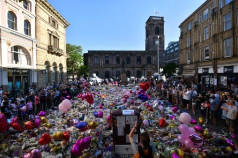 People gather at the flowers and messages of support in St Ann's Square in Manchester, northwest England on May 26, 2017, placed in tribute to the victims of the May 22 terror attack at the Manchester Arena. The terror attack in Manchester has thrown a spotlight on hardline Islamist exiles among opponents of former Libyan dictator Moamer Kadhafi who live in the northwestern English city, experts said. / AFP PHOTO / Ben STANSALL
