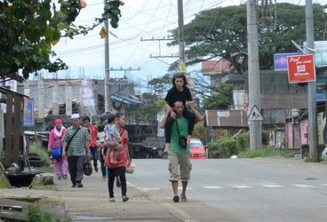 A resident carries a relative as they evacuate from their homes in Marawi, in southern island of Mindanao on May 27, 2017, after government planes and helicopters bombed Islamic militants position.  Philippine security forces dropped more bombs on a southern city where they have been battling Islamist militants for five days, vowing no let up despite the start of Ramadan. / AFP PHOTO / TED ALJIBE