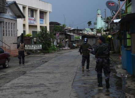 Government troops patrol a deserted street near the position of Islamic militantst as government planes and helicopters bombed militants position in Marawi, in southern island of Mindanao on May 27, 2017. The Philippine military warned May 26 it would impose censorship to protect "national security" across the southern third of the country where martial law has been declared. / AFP PHOTO / TED ALJIBE