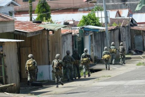 Philippine marines patrol a deserted street in Marawi on the southern island of Mindanao on May 30, 2017. Philippine authorities on May 30 warned Islamist militants occupying parts of a southern city to surrender or die, as attack helicopters pounded the gunmen's strongholds where up to 2,000 residents were feared trapped. / AFP PHOTO / TED ALJIBE