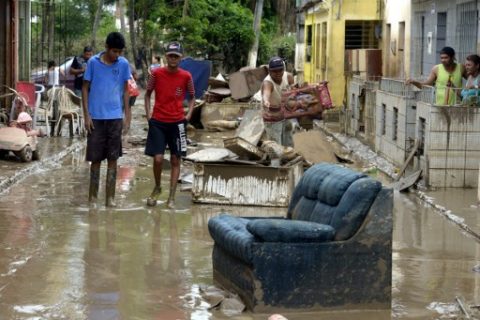 Residents of the city of Barreiros try to save their belongings form their homes affectd by floods, due to heavy rains in Pernambuco state, northeastern Brazil, on May 30, 2017. 50,000 people fled their homes in the Brazilian northern states of Pernambuco and Alagoas after a storm led to floods, landslides and the falling of trees, leaving at least six dead this weekend. / AFP PHOTO / Leo Caldas