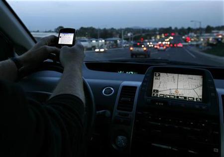 A driver uses his smart phone while in traffic in Encinitas, California December 10, 2009. REUTERS/Mike Blake
