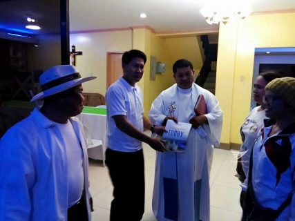 A Catholic priest receives a copy of the PASUGO or "God's Message" magazine in Mindanao. (Eagle News Service)