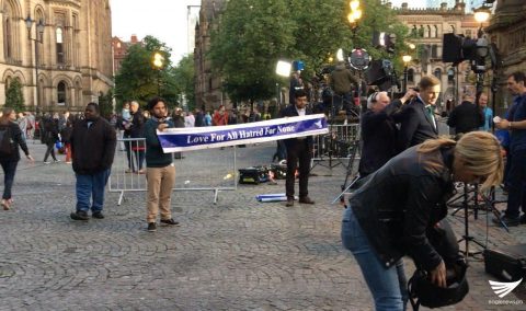 "Love for All, Hatred for None," says this sign held by two men in Manchester following a deadly blast at the Manchester Arena during the Ariana Grande concert that killed 22 people, including children. ((Eagle News Service, EBC London Bureau)