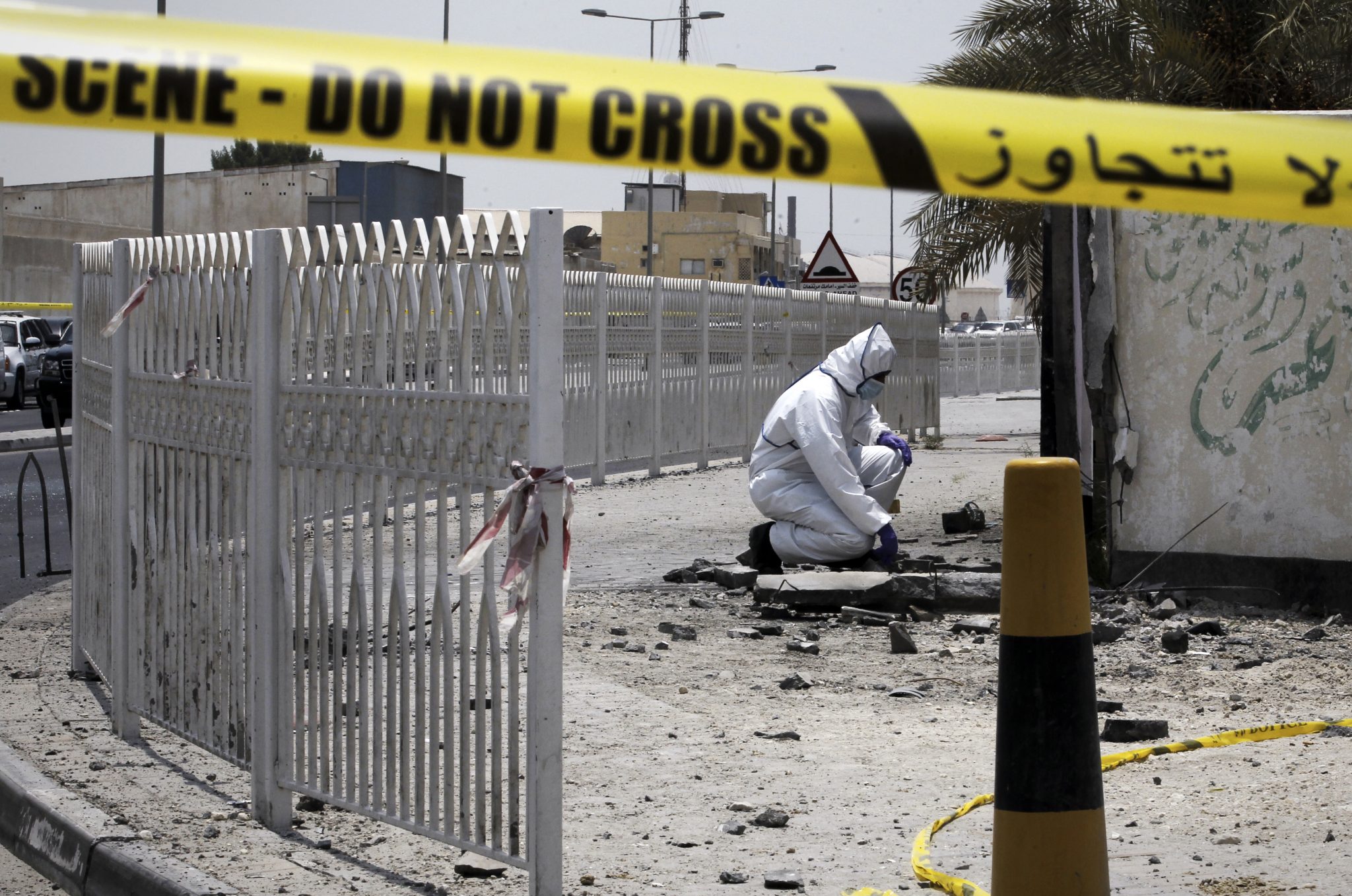 A Bahraini forensic police officer inspects the site of a bomb blast in the village of Sitra, south of Manama, on July 28, 2015. The blast killed two Bahraini policemen and wounded six others in an area often shaken by clashes between security forces and Shiite Muslim protesters, according to the interior ministry. Bahrain has seen frequent unrest since the minority Sunni rulers of the small Gulf kingdom crushed a Shiite-led uprising four years ago. AFP PHOTO / MOHAMMED AL-SHAIKH / AFP PHOTO / MOHAMMED AL-SHAIKH