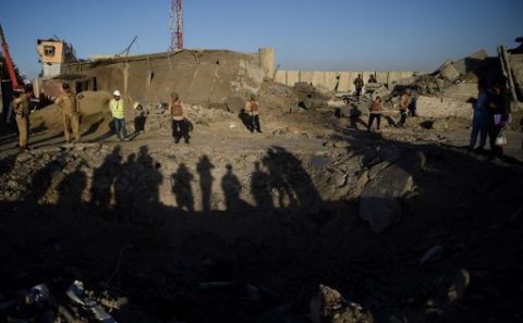 Foreign security forces and Afghan private security personnel stand near the crater left by a truck bomb attack in Kabul on May 31, 2017. At least 80 people were killed and hundreds wounded May 31 when a massive truck bomb ripped through Kabul's diplomatic quarter, bringing carnage to the streets of the Afghan capital and shattering windows hundreds of metres away. / AFP PHOTO / WAKIL KOHSAR