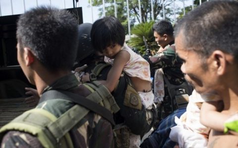 A soldier carries a girl that was trapped trapped for 11 days with her family at Pangarungan Village in Marawi City, on the southern island of Mindanao on June 3, 2017. Philippine troops battle Islamists in the southern city of Marawi, with nearly two weeks of clashes claiming at least 175 lives. / AFP PHOTO / RODY
