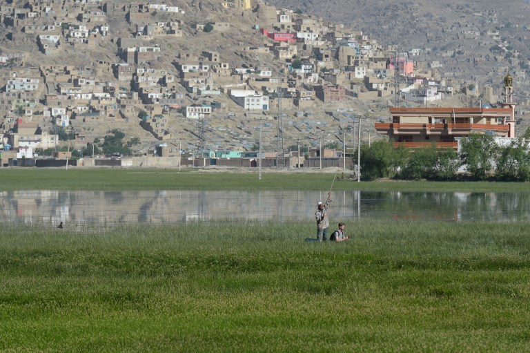 This photograph taken on May 29, 2017 shows birdwatchers on a small craft at the Kol-e Hashmat Khan wetland in the outskirts of Kabul. A rare Afghan marsh that was once a royal hunting ground is set to come under the official protection of the UN environment agency, with the aim of saving hundreds of migratory bird species. / AFP PHOTO / SHAH MARAI / To go with Afghanistan-environment-climate,FOCUS by Anne Chaon