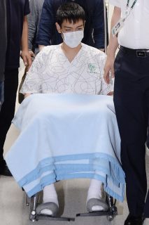 South Korean pop star T.O.P (on wheel-chair), rapper of K-pop boy band Big Bang, emerges from the intensive care unit of a hospital in Seoul on June 9, 2017. South Korean pop star T.O.P regained consciousness on June 9 after spending three days in a critical condition in intensive care at a Seoul hospital following an apparent drugs overdose. / AFP PHOTO / YONHAP / str / REPUBLIC OF KOREA OUT NO ARCHIVES RESTRICTED TO SUBSCRIPTION USE