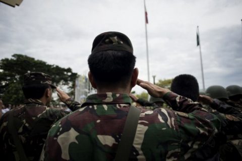 Soldiers salute during a flag raising ceremony at the Lanao Del Sur provincial capital of Marawi on the southern island of Mindanao on June 12, 2017. Embattled Philippine troops struggling to force out Islamist militants from a southern city raised the national flag for Independence Day on June 12, in a tearful ceremony dedicated to the scores killed during the conflict. / AFP PHOTO / NOEL CELIS