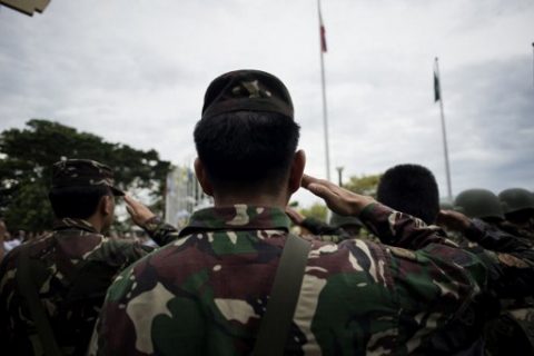 Soldiers salute during a flag raising ceremony at the Lanao Del Sur provincial capital of Marawi on the southern island of Mindanao on June 12, 2017. Embattled Philippine troops struggling to force out Islamist militants from a southern city raised the national flag for Independence Day on June 12, in a tearful ceremony dedicated to the scores killed during the conflict.  / AFP PHOTO / NOEL CELIS