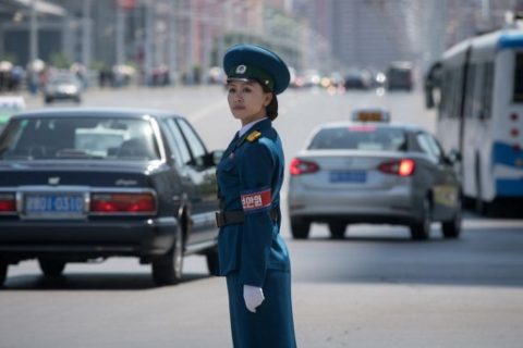 In a photo taken on June 5, 2017 a traffic security officer stands on duty at an intersection in Pyongyang. Officially known as traffic security officers but universally referred to as traffic ladies, they are chosen for their looks in a society that remains traditionalist in many respects. They must leave the role if they marry, and have a finite shelf-life, with compulsory retirement looming at just 26. The 300-odd ladies are unique to Pyongyang, which North Korean authorities are always keen to present in the best possible light despite their nuclear-armed country's impoverished status, and ensure a steady supply of photogenic young women who are the favourite subject of visiting tourists and journalists. / AFP PHOTO / Ed JONES / To go with NKorea-transport-tourism-gender-police, FOCUS by Sebastien Berger