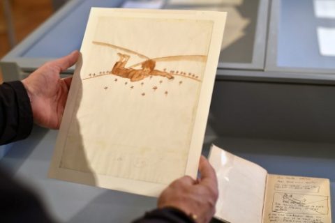(FILES) This file photo taken on May 17, 2017 shows a person holding a drawing by Frenchman Antoine de Saint-Exupery at the Museum of Old Toulouse prior to the sale of a set of 12 drawings and 7 letters by Saint-Exupery in Paris on June 14, 2017. Two watercolours of 'Le Petit Prince' (The Little Prince) by Antoine de Saint-Exupery were sold on June 14, 2017 for 500, 000 euro (560,149 USD) according to the Artcurial auction house. / AFP PHOTO / REMY GABALDA / RESTRICTED TO EDITORIAL USE - MANDATORY MENTION OF THE ARTIST UPON PUBLICATION - TO ILLUSTRATE THE EVENT AS SPECIFIED IN THE CAPTION