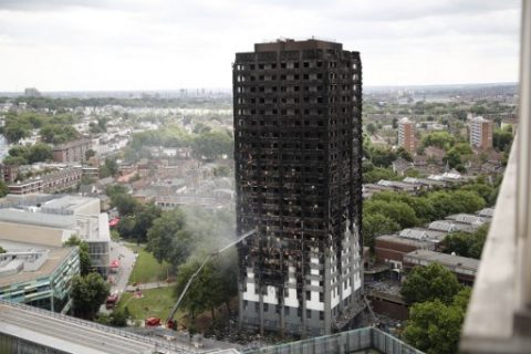 An automated hose sprays water onto Grenfell Tower, a residential tower block in west London that was caught in a huge blaze on June 15, 2017. Firefighters searched for bodies today in a London tower block gutted by a blaze that has already left 12 dead, as questions grew over whether a recent refurbishment contributed to the fire. / AFP PHOTO / Tolga AKMEN
