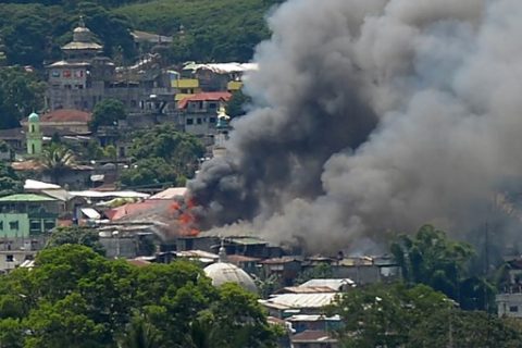 Smoke billows from burning buildings in Marawi on the southern island of Mindanao on June 18, 2017, after Philippine Airforce planes pounded Islamist militants' positions.  Philippine troops pounded Islamist militants holding parts of southern Marawi city with air strikes and artillery on June 17 as more soldiers were deployed and the death toll rose to more than 300 after nearly a month of fighting. / AFP PHOTO / Ted ALJIBE
