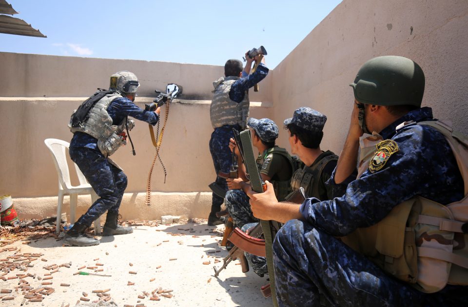 Iraqi forces take a position on the roof of a building as they advance towards Mosul's Old City on June 18, 2017, during the ongoing offensive by Iraqi forces to retake the last district still held by the Islamic State group. Military commanders told AFP the assault had begun at dawn, after overnight air strikes by the US-led coalition backing Iraqi forces, and that the jihadists were putting up fierce resistance. / AFP PHOTO / AHMAD AL-RUBAYE