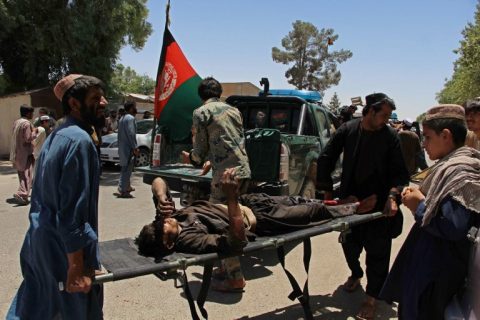 Afghan men carry a victim of a powerful car bomb in Lashkar Gah, the capital of Helmand province, on June 22, 2017. Twenty people were killed June 22 when a powerful car bomb struck a bank in Afghanistan's Lashkar Gah city as government employees were queueing to withdraw salaries, the latest bloody attack during the holy month of Ramadan.  / AFP PHOTO / NOOR MOHAMMAD