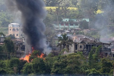 Black smoke billows from burning houses after Philippine Airforce attack planes conducted aerial bombings on Islamist militants' positions in Marawi on the southern island of Mindanao on June 26, 2017. Hundreds of militants, flying the flag of the Islamic State group and backed by foreign fighters, seized swathes of Marawi in the southern region of Mindanao last month, sparking bloody street battles and raising regional concern. / AFP PHOTO / Ted ALJIBE