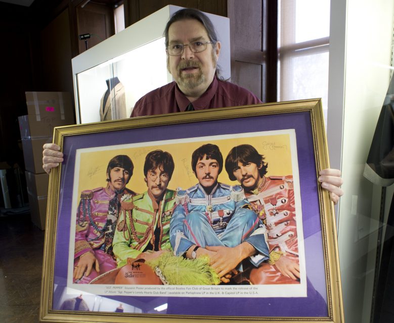 Heritage Auctions" Gary Shrum holds an autographed copy of Beatles Sgt. Pepper's Lonely Hearts Club Band Fan Club Poster (EMI, 1967), AFP PHOTO/