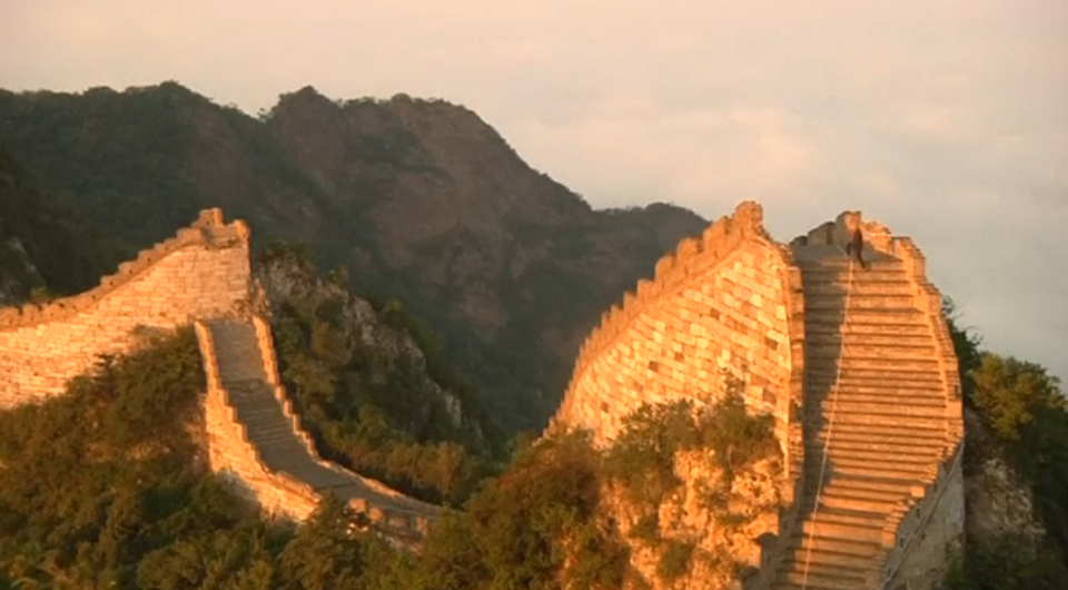 As the sun rises over one of the most dangerous and least-restored stretches of China's Great Wall, a line of pack mules emerge from the gloom of a dense forest still draped in mist and dew. Photo grabbed from Reuters video file.