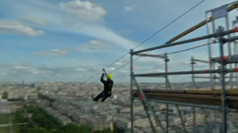 Do you want to know how fast a tennis ball goes? Zip down a line strung from the second floor of the Eiffel tower, 115 meters above the ground.(photo grabbed from Reuters video)